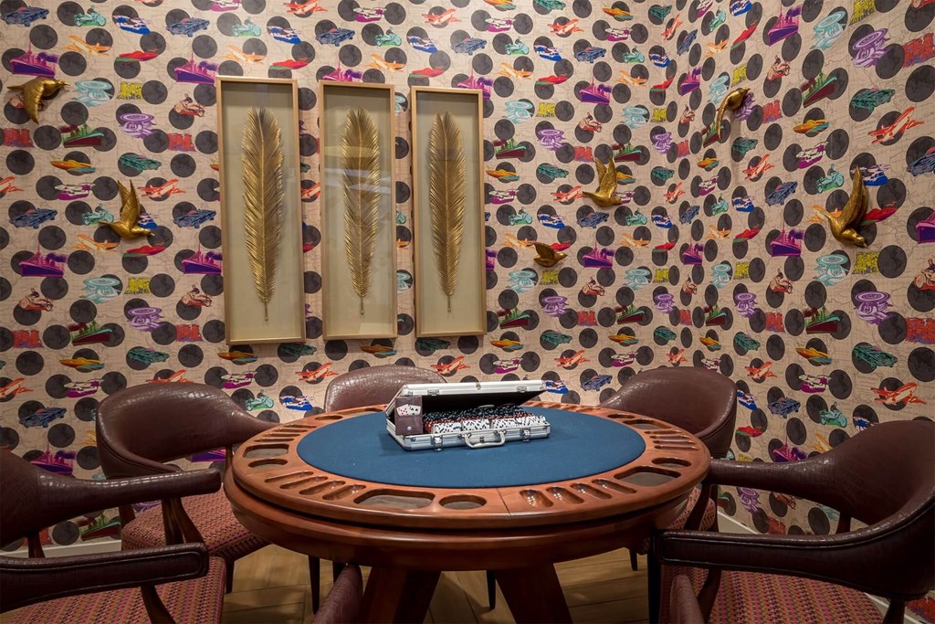 A poker table with chairs and a deck of cards on it.