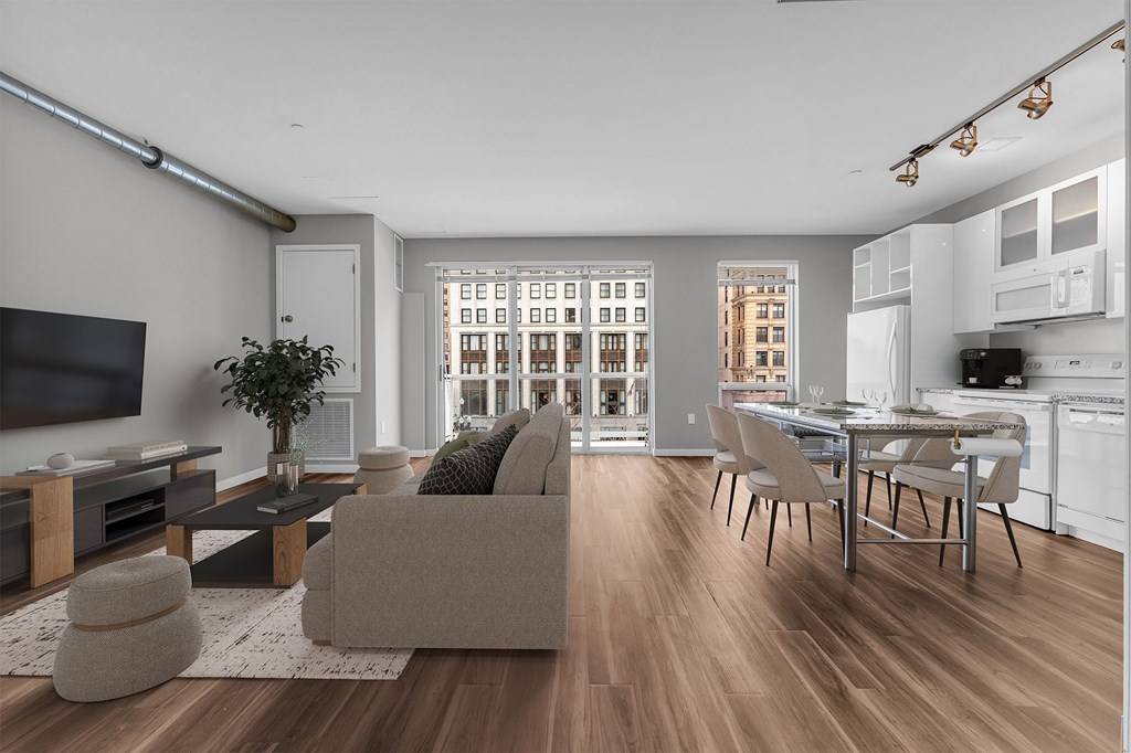 A modern living room with a grey couch and a wooden floor.