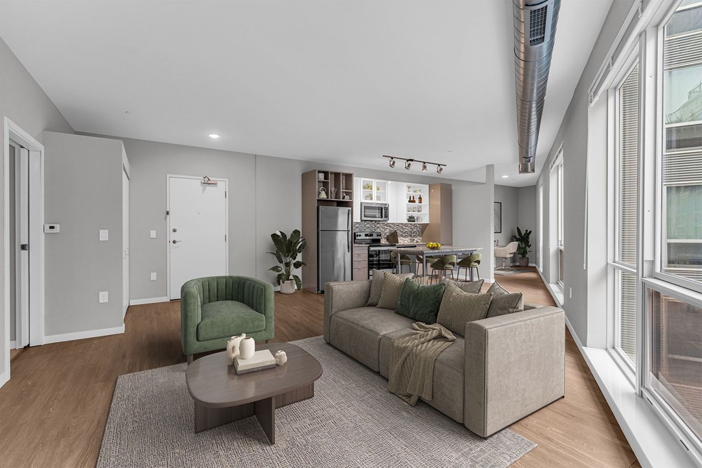 A living room with a green armchair and a grey sofa.