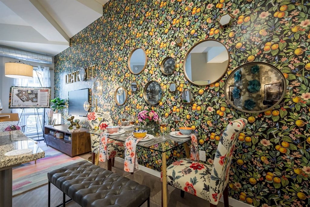 A dining room with a floral wallpaper and a table set for two.