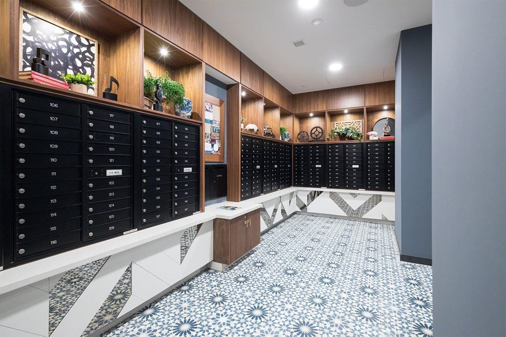 A hallway with a row of mailboxes on the wall.