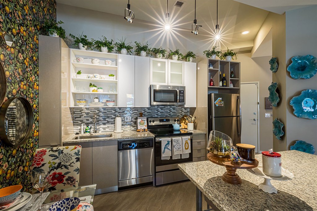 A modern kitchen with a dining table set for two.