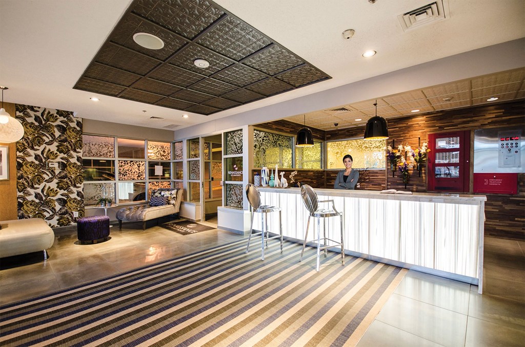 the lobby of a hotel with a bar and chairs