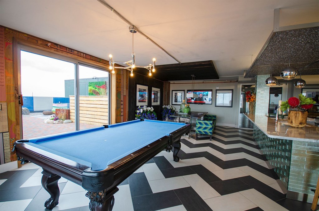a pool table in a living room with a view of the ocean