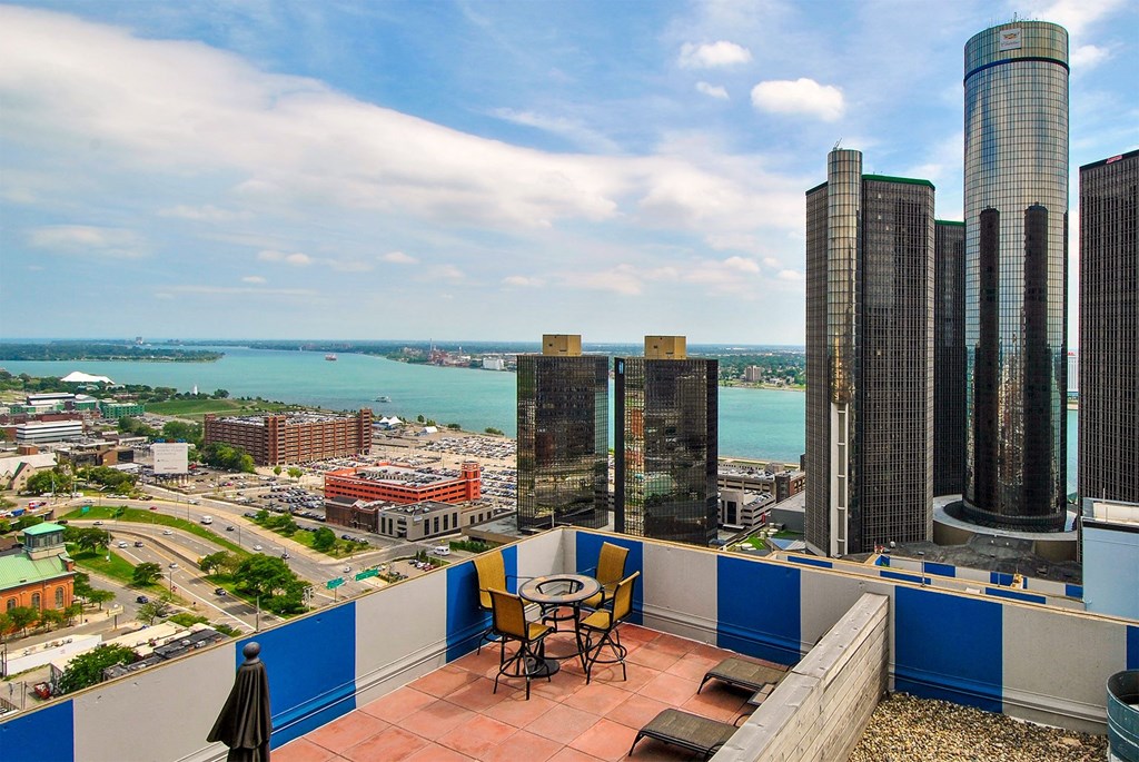 a balcony with a view of the city and a table and chairs