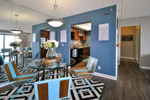 a dining room and kitchen with a glass table and chairs