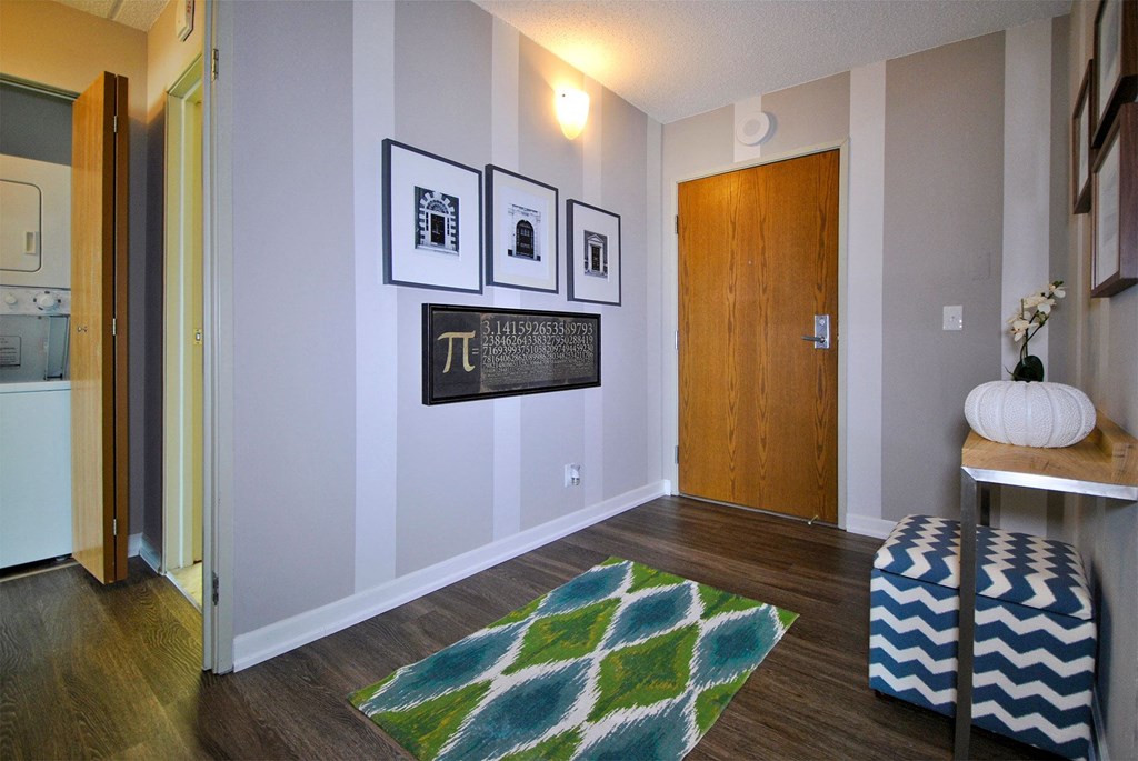 a living room with a rug and pictures on the wall