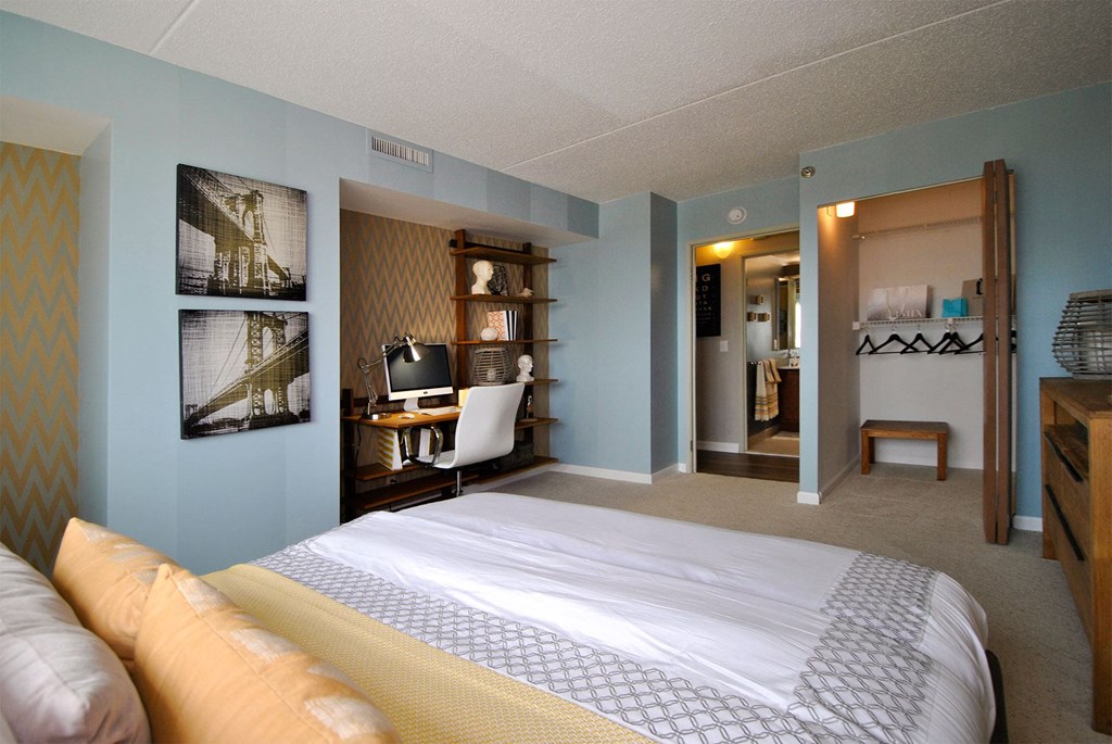 a bedroom with a bed and a desk in a hotel room