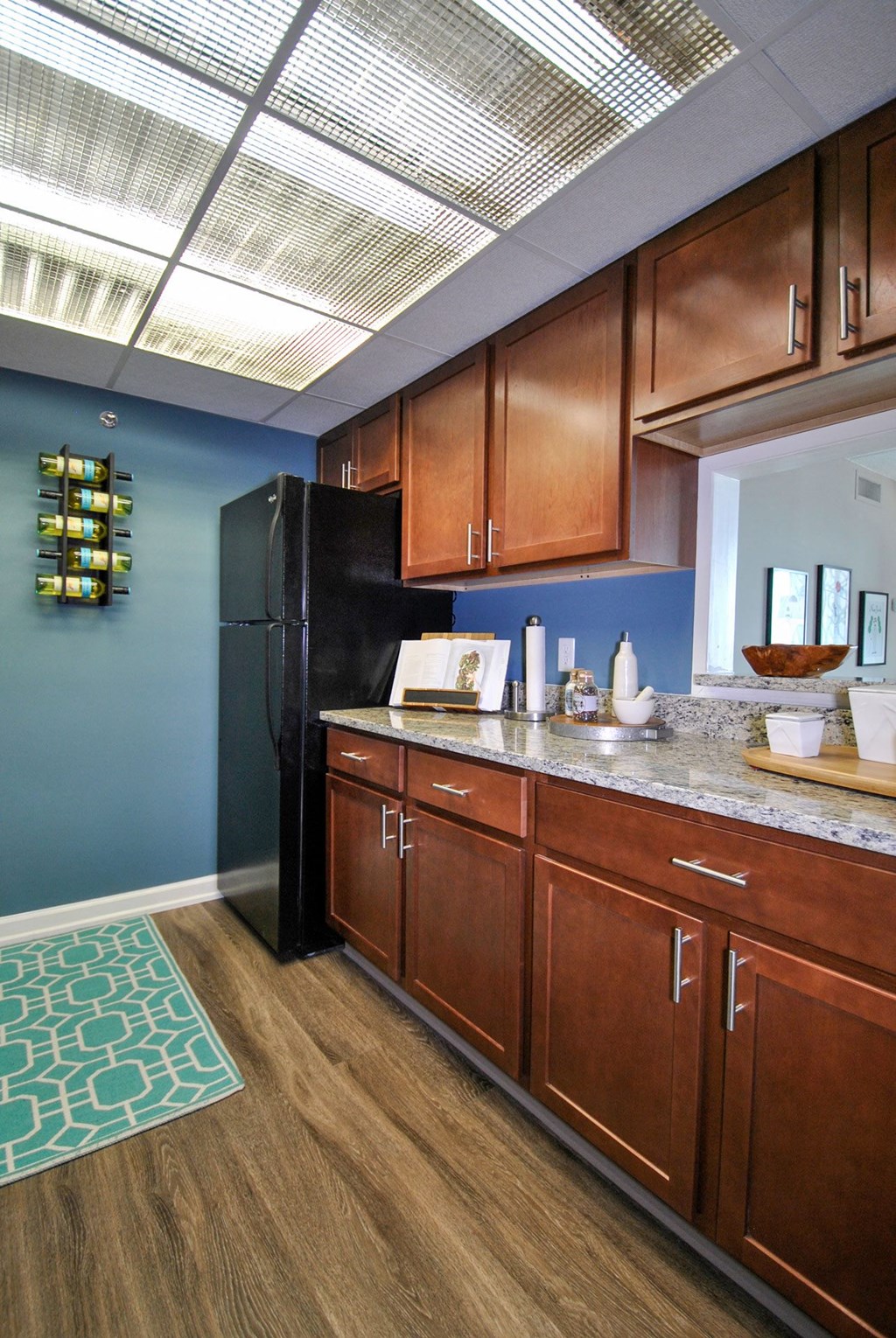 a kitchen with wooden cabinets and a black refrigerator