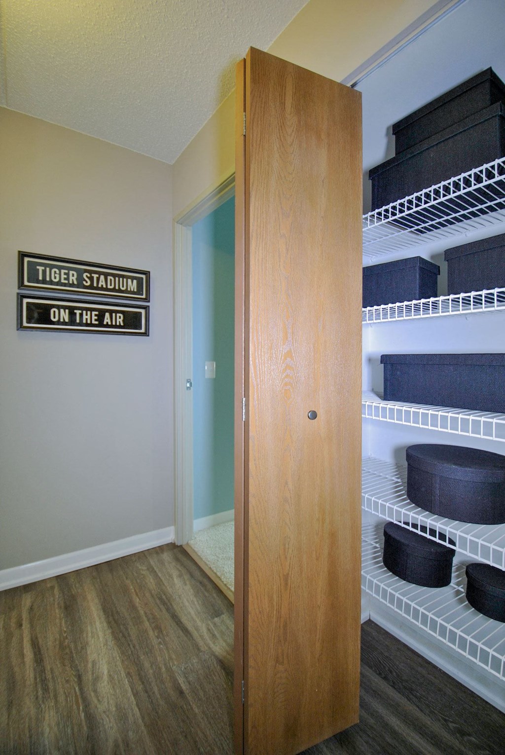 a walk in closet with a tiger stadium on the air sign
