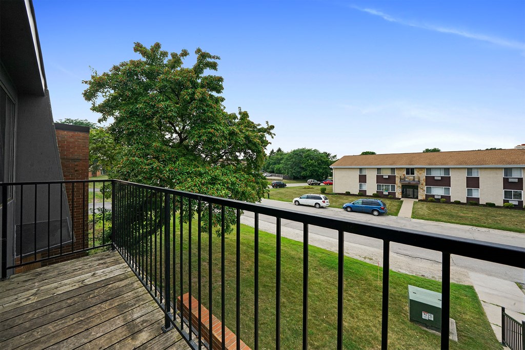 a balcony with a view of a yard and a building