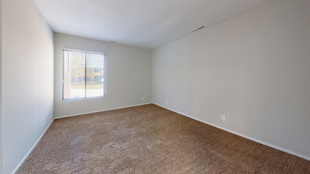 an empty room with carpet and a window