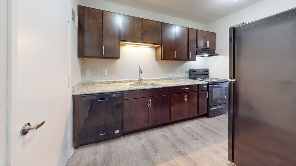 a kitchen with wooden cabinets and a stainless steel refrigerator