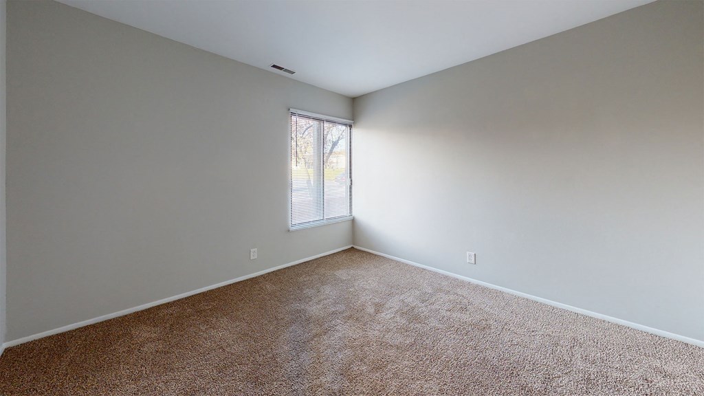 an empty room with carpet and a window