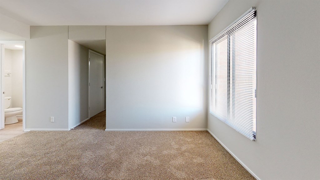 an empty room with a large window and a closet