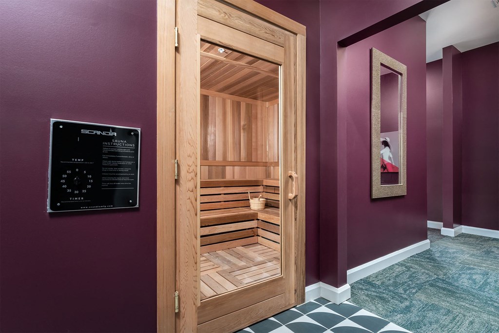 a sauna in a room with purple walls and a black and white tile floor