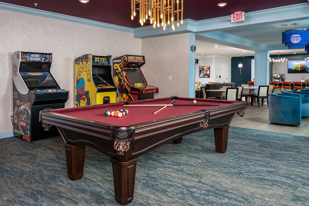 a games room with a pool table and arcade games
