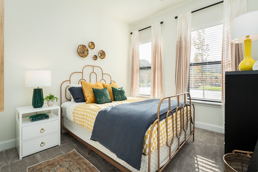 a bedroom with a bed and two windows