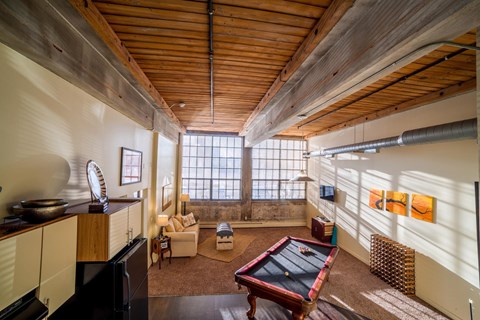 A room with a pool table and a television.