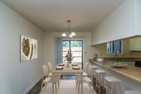 A dining room with a table set for four.