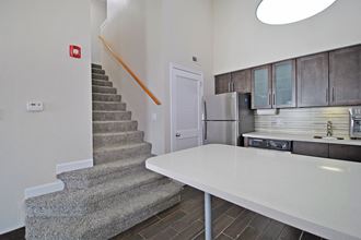 a kitchen with a white counter next to a stairwell