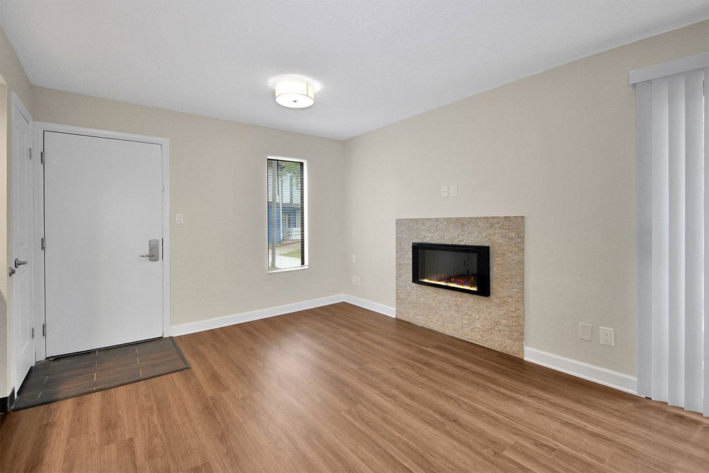 a living room with a fireplace and wooden floors