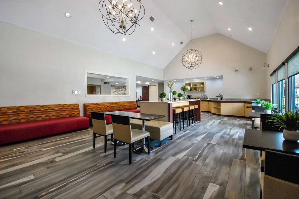 a dining room with tables and chairs and a kitchen in the background