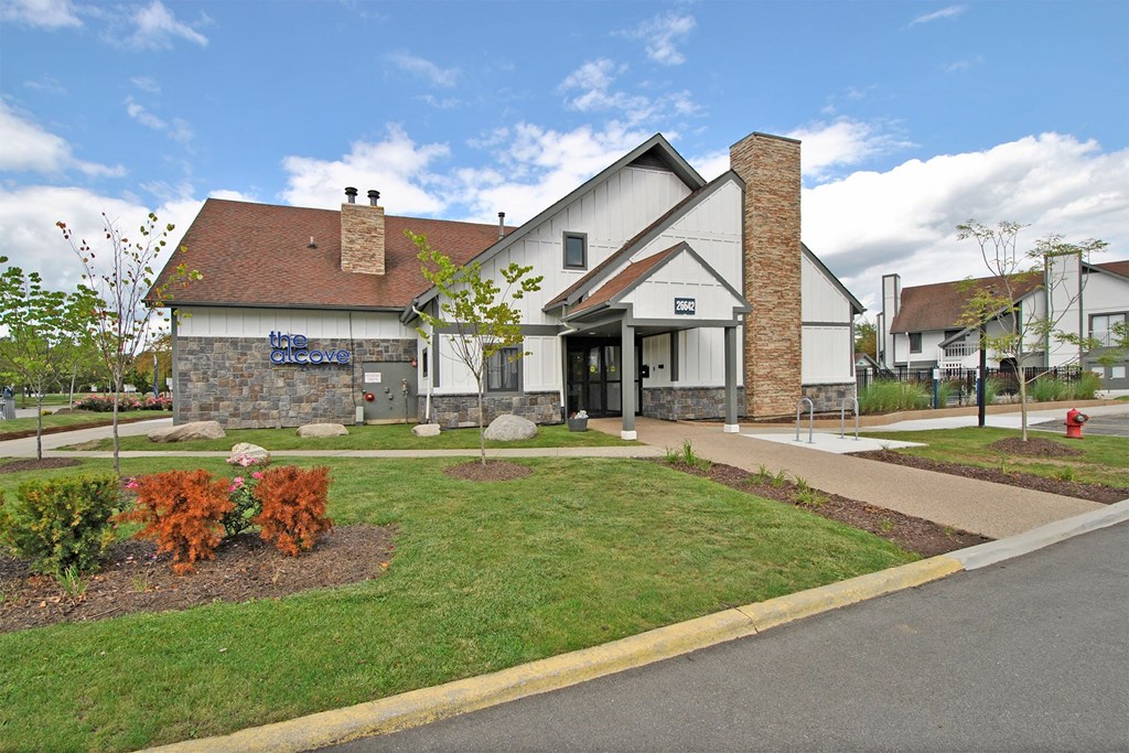 the front of a house with a lawn and a sidewalk