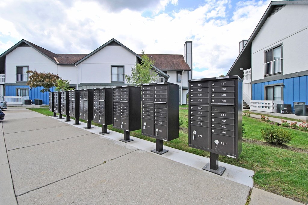 a row of mailboxes on a sidewalk in front of houses