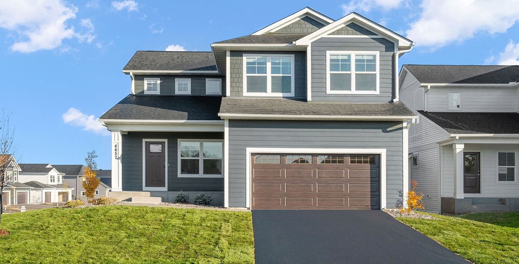 a house with a garage door and a lawn