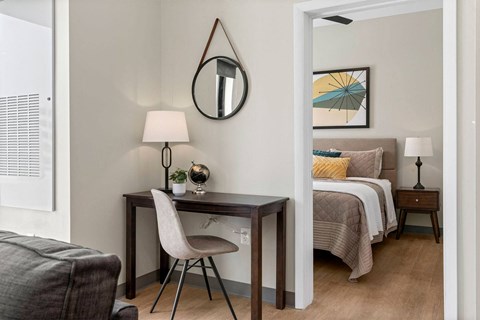 a bedroom with a bed and a desk in a room
