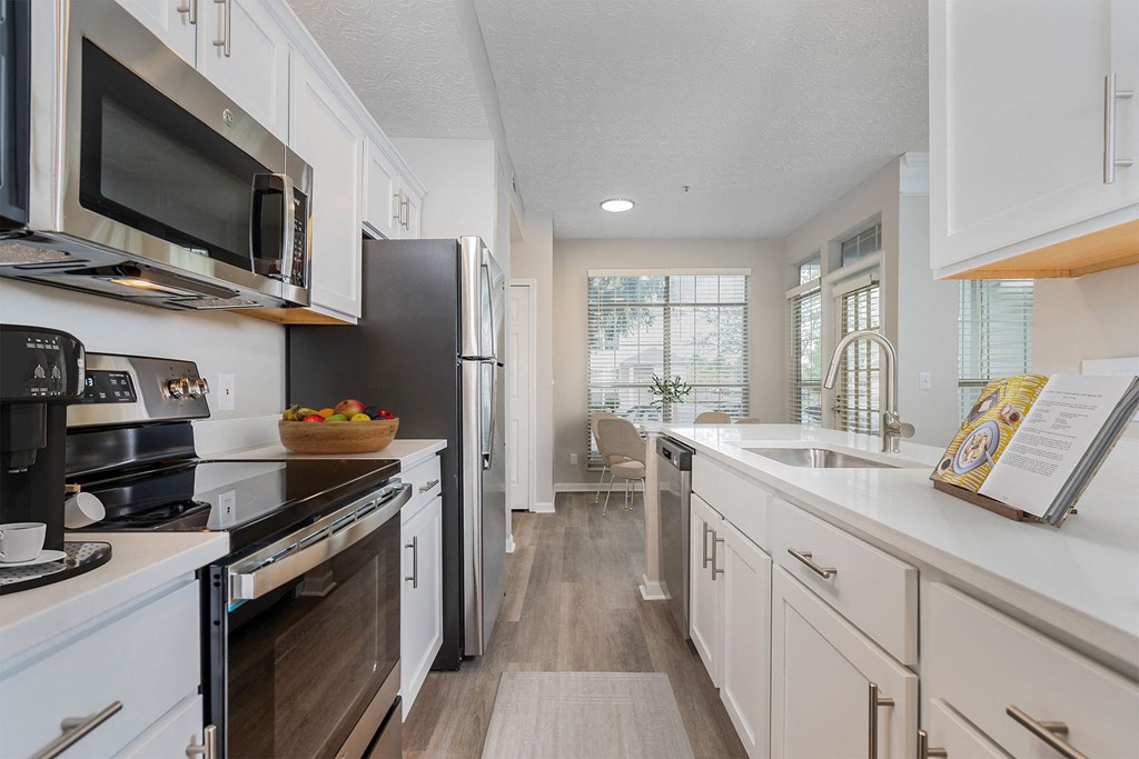 a kitchen with white cabinets and stainless steel appliances