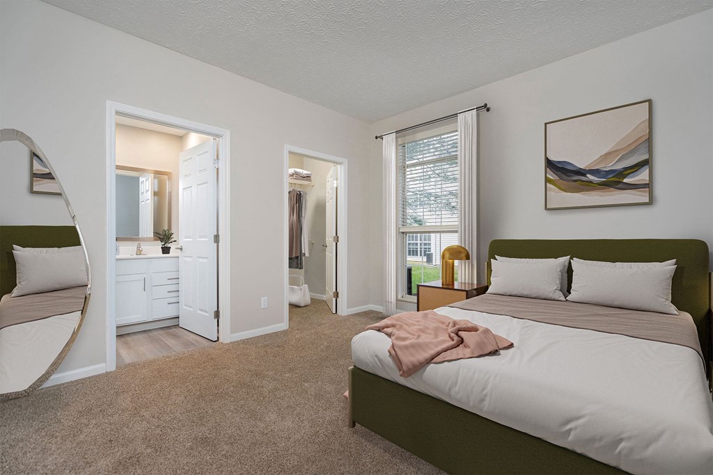 a bedroom with a bed and a mirror and a bathroom