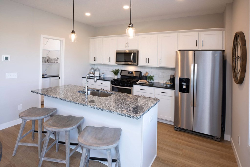 a kitchen with white cabinets and a granite counter top