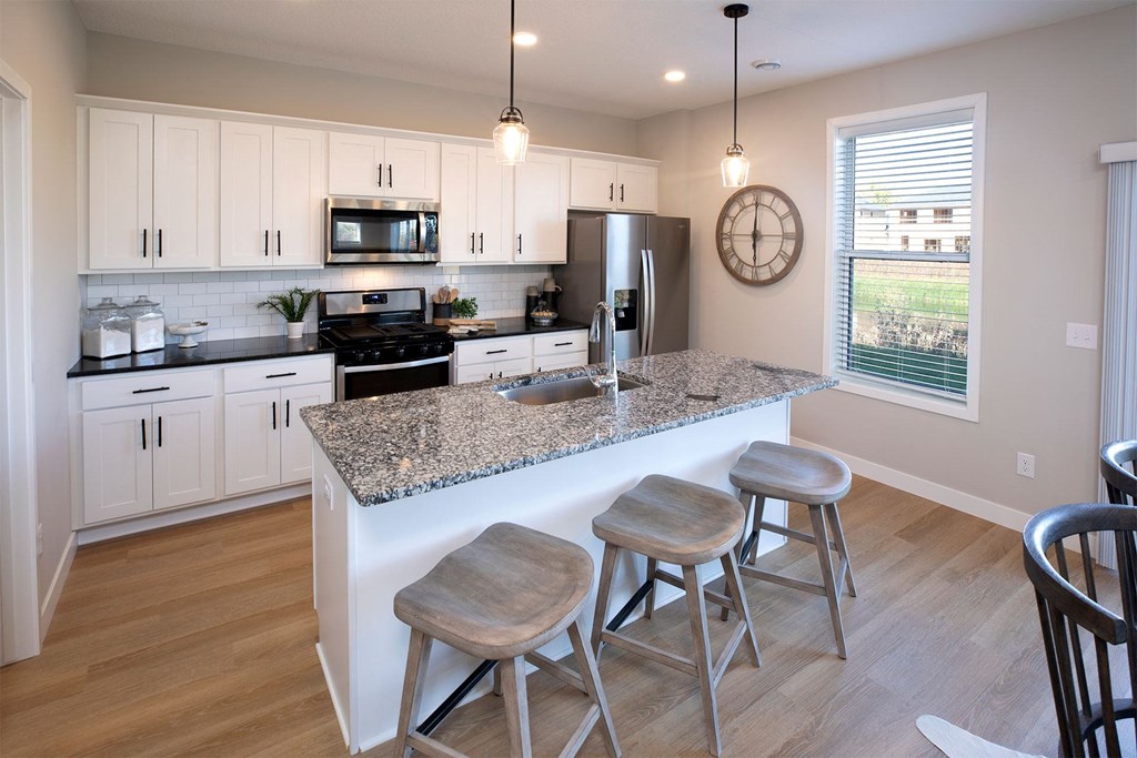 a kitchen with white cabinets and a granite counter top