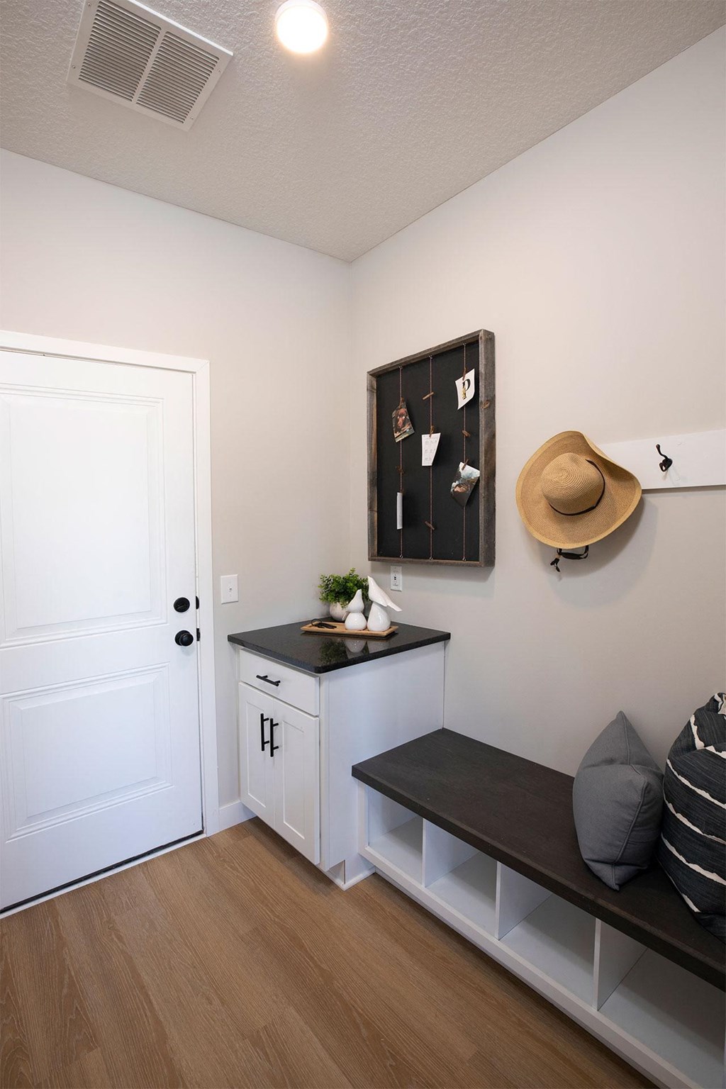 a room with a desk and a hat on the wall