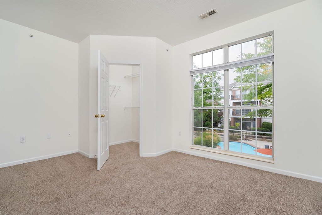 a bedroom with a large window and a door to a pool