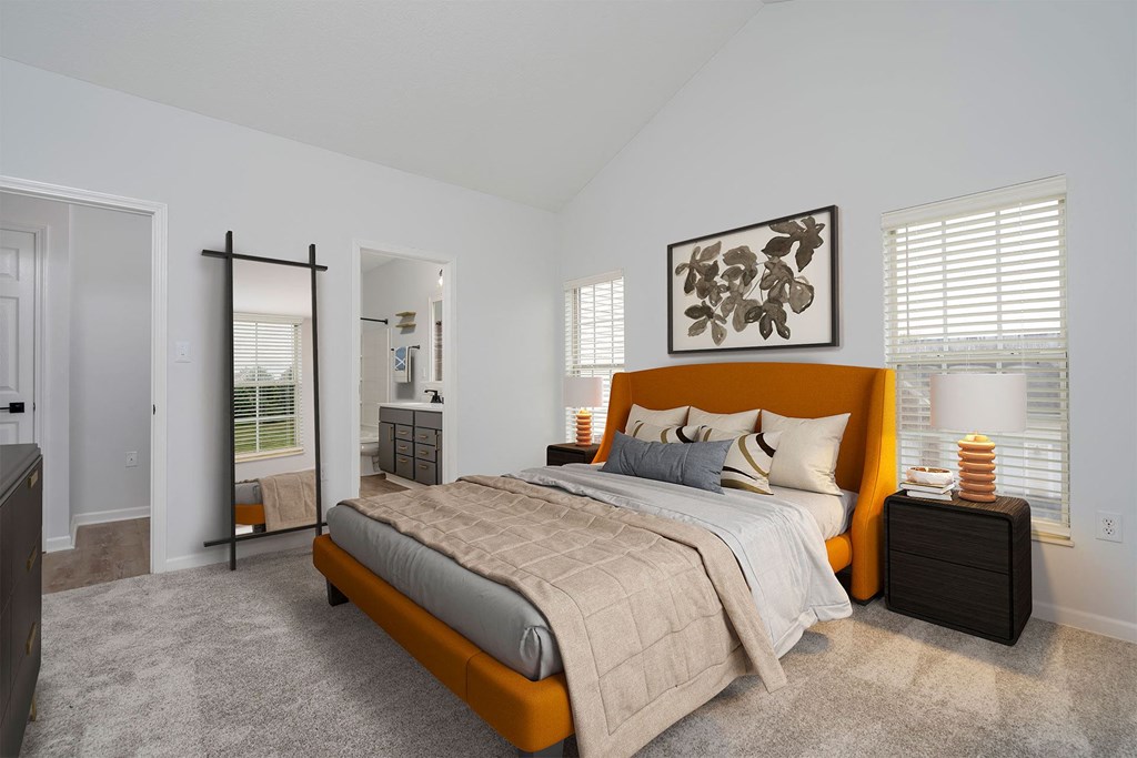 a bedroom with a bed and a mirror and a bathroom