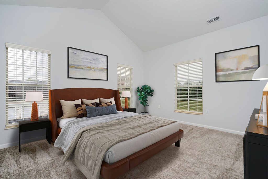 a bedroom with a bed and two windows