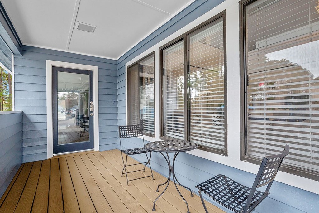 A balcony with a table and chairs.