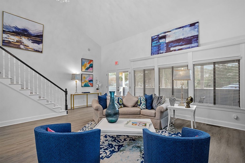 A living room with a blue chair and a white couch.