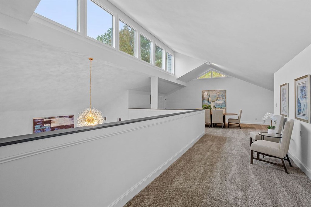A living room with a couch, chairs, and a painting on the wall.