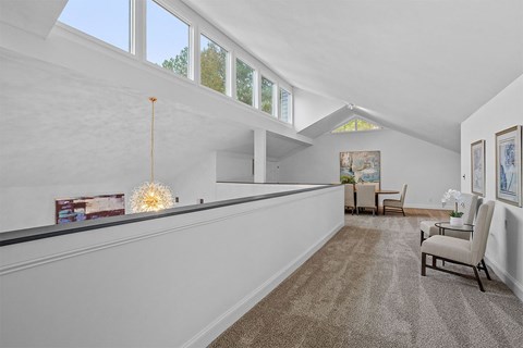 A living room with a couch, chairs, and a painting on the wall.
