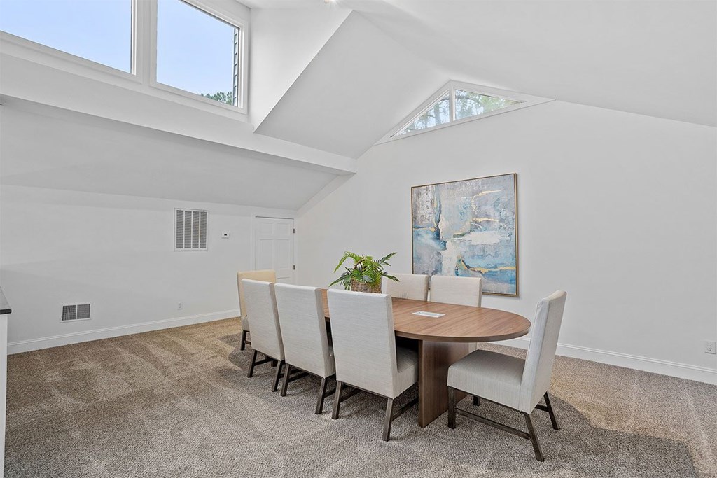 A dining room with a round table and chairs.