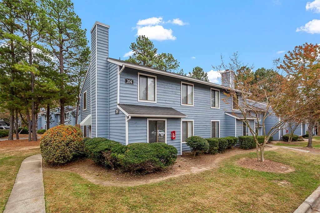 A blue house with a red door and a chimney.