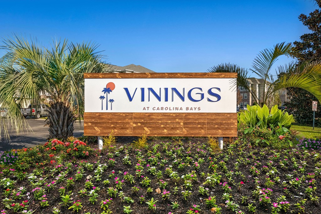 a sign for the vinings at carolina blvd in front of plants