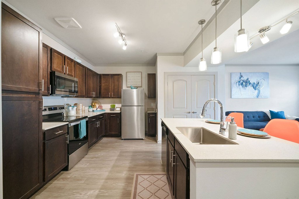 a kitchen with dark wood cabinets and white countertops