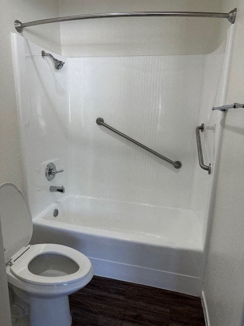 a white bathroom with a toilet and a shower