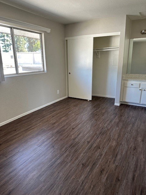 an empty living room with wooden floors and a window