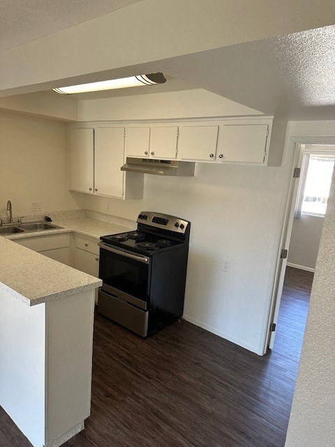 an empty kitchen with white cabinets and a black stove
